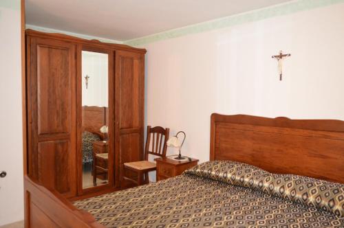a bedroom with a bed and a cross on the wall at La Stella Del Pollino in San Lorenzo Bellizzi