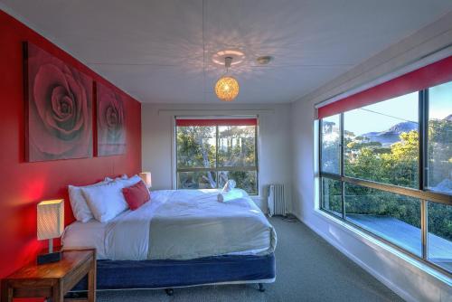 a bedroom with a bed and a large window at Cove Beach Apartment 2 in Coles Bay
