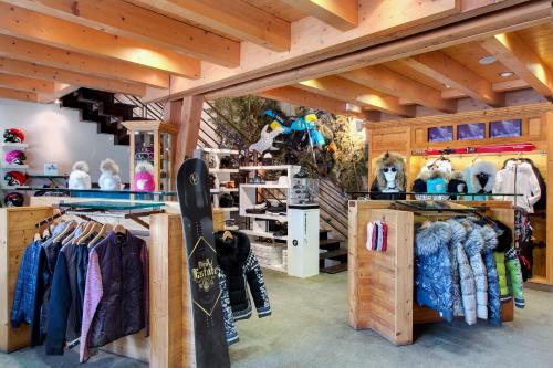a ski shop with a lot of clothes and snowboards at Hôtel Les Barmes De l'Ours in Val-d'Isère
