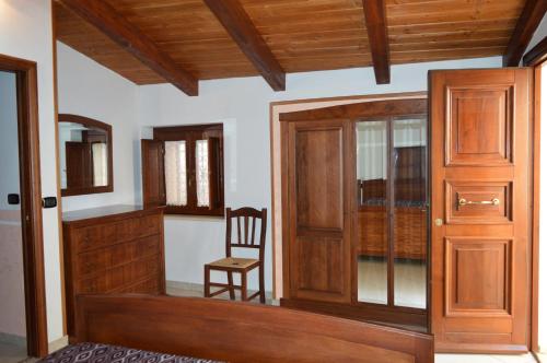 a room with a wooden door and a chair at La Stella Del Pollino in San Lorenzo Bellizzi