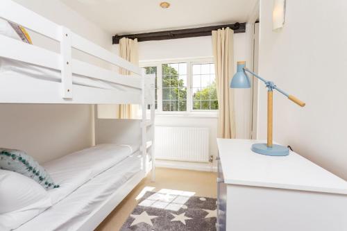 een slaapkamer met een stapelbed en een bureau bij The Queen Edith Place - Lovely 6BDR Home in Secluded Area in Cambridge