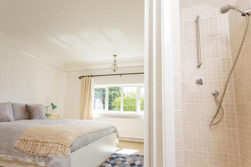 a bedroom with a bed and a shower at The Queen Edith Place - Lovely 6BDR Home in Secluded Area in Cambridge