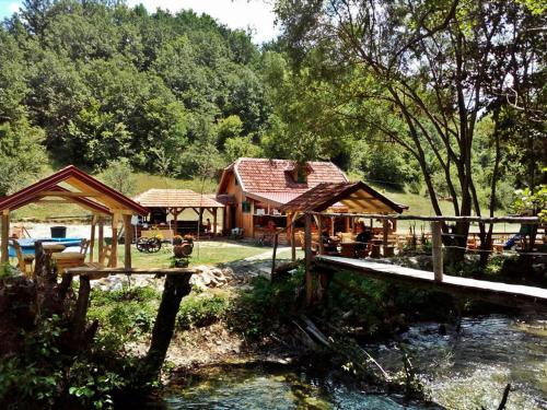a house with a bridge next to a river at Seoski turizam Ziličina Rogatica in Rogatica