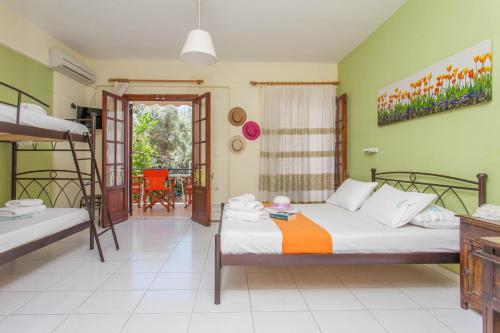 a bedroom with two beds and a balcony at Ionio Sea Poros Studios in Mikros Gialos