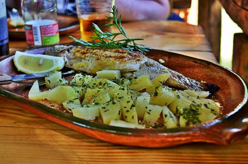 a plate of food with meat and potatoes on a table at Seoski turizam Ziličina Rogatica in Rogatica