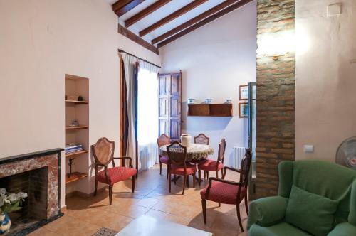 a living room with a fireplace and a table and chairs at Villamilagro in Sueca