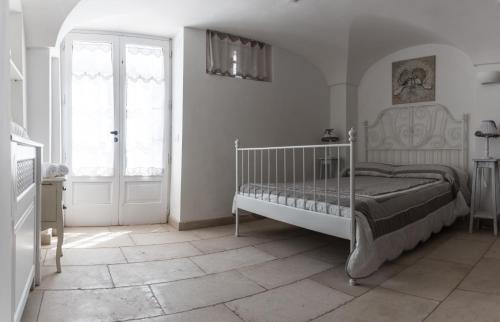 a white bedroom with a bed and a window at Masseria Luco in Martina Franca