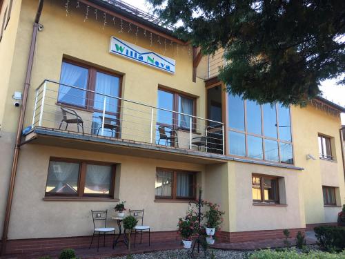 a building with tables and chairs on a balcony at Willa Nova in Wisła