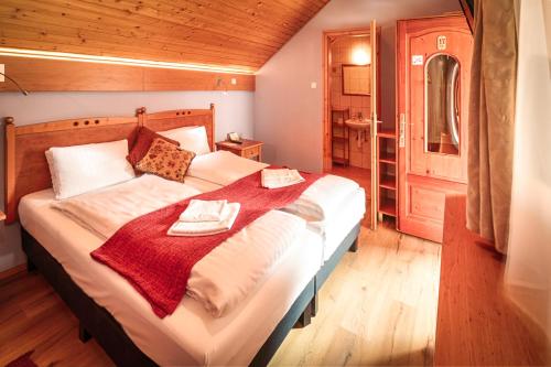 a bedroom with a bed with two towels on it at Ópusztaszeri Erdei Wellness Vendégház in Ópusztaszer