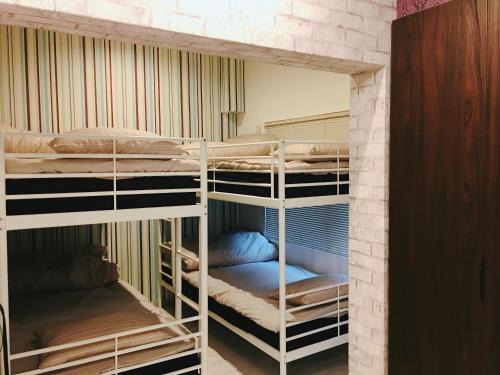 a room with three bunk beds in a room at Guest House Fukuoka W001 in Kasuga