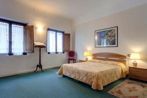 - une chambre avec un lit, une chaise et des fenêtres dans l'établissement Paradiso, à Florence