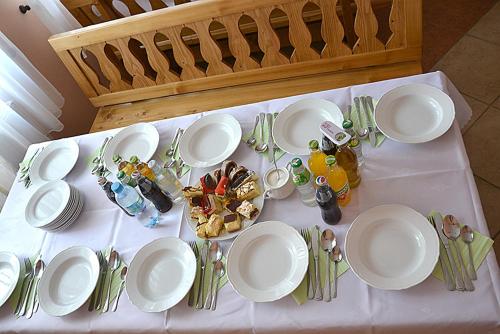 einen Tisch mit weißen Tellern und Küchenutensilien darauf in der Unterkunft Bumerang in Nowa Biała