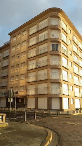 a large apartment building in front of a parking lot at Nevada in Koksijde