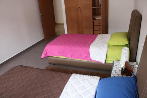 a bedroom with a bed with pink and green sheets at Appartement ,Tram Parking and wifi gratui in Casablanca