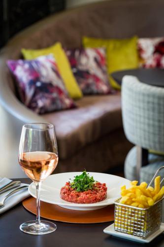 a plate of food and a glass of wine on a table at Sofitel Frankfurt Opera in Frankfurt/Main