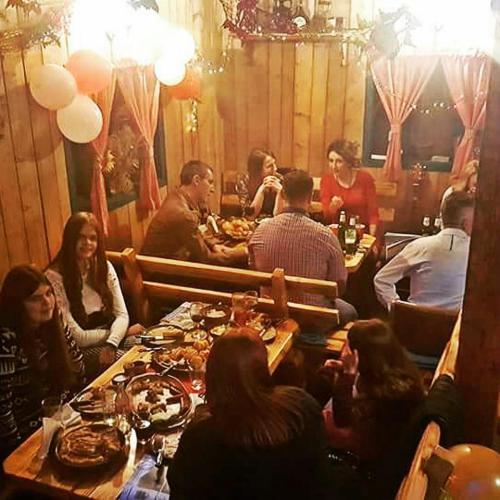 a group of people sitting at a table in a restaurant at Seoski turizam Ziličina Rogatica in Rogatica