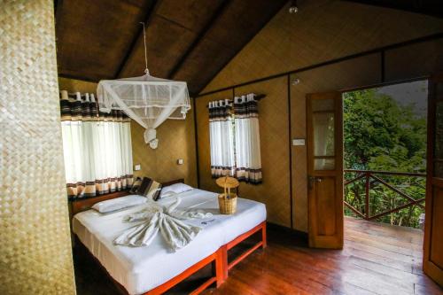 1 dormitorio con cama y lámpara de araña en The Thick Forest en Sigiriya