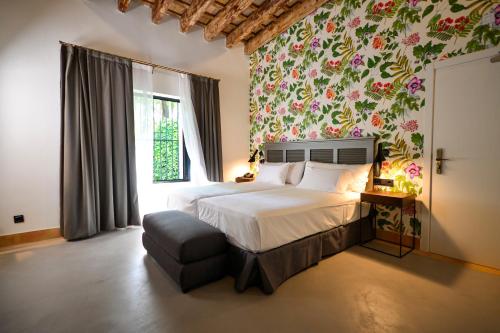 a bedroom with a large bed with a floral wallpaper at Legado Alcazar Hotel in Seville