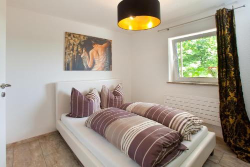 uma sala de estar com um sofá com almofadas e uma janela em Residenz Cheval Messe FN em Ravensburg