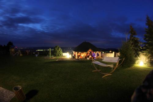 a yard with a chair and a tent at night at Apartamenty Pod Łysicą & SPA - przy stoku, basen, jacuzzi, sauna in Krajno Pierwsze