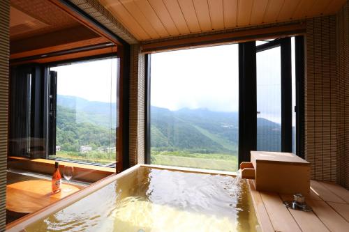 a jacuzzi tub with a view of a mountain at Hotel Higashidate in Yamanouchi