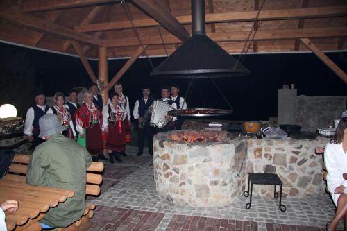 a group of people standing around a grill in a room at Apartamenty Pod Łysicą & SPA - przy stoku, basen, jacuzzi, sauna in Krajno Pierwsze
