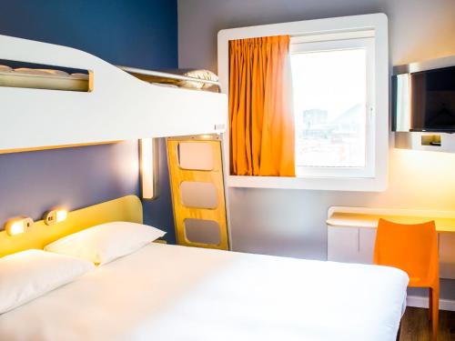 a bedroom with a bed and a desk and a window at ibis budget Copiapo in Copiapó
