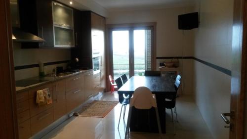 a kitchen with a table and chairs in a room at Apartamento do Atlantico in Gala