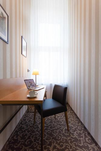 a room with a desk with a chair and a laptop at Hotel Schwaiger in Prague