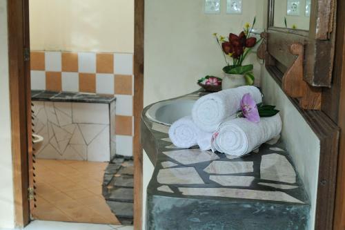 a bathroom with towels sitting on a glass shelf at Puri Brata in Parangtritis