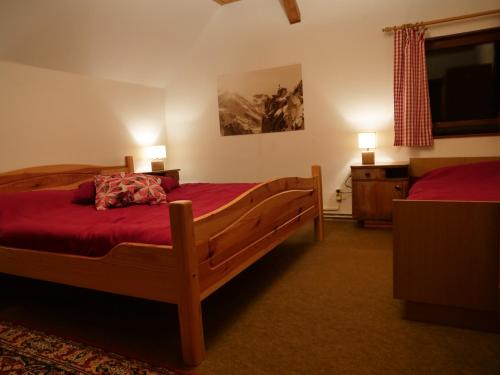 una camera con due letti con lenzuola rosse e due lampade di Urige Almhütte Innerkrems a Innerkrems