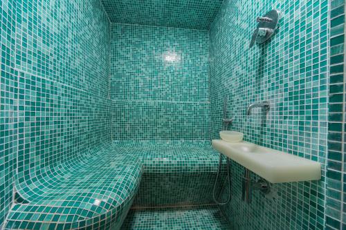 a blue tiled bathroom with a toilet and a sink at Villa La Fornace in Tavarnelle in Val di Pesa
