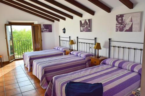 a group of three beds in a room at Cortijo La Panadera in Pozoblanco