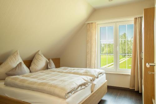 a bedroom with a bed and a large window at Schrebenza in Burg Kauper