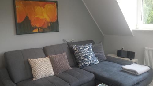 a living room with a gray couch with pillows at Mach mal Pause bei Geni & Bernd in Kleineichen