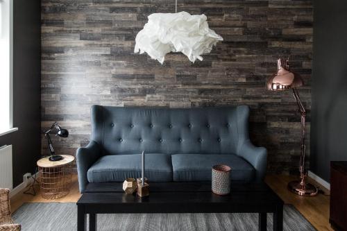 a living room with a blue couch and a table at Acco Luxury Apartments in Akureyri