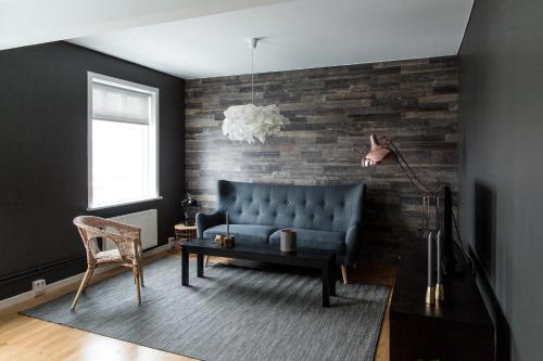 a living room with a blue couch and a brick wall at Acco Luxury Apartments in Akureyri