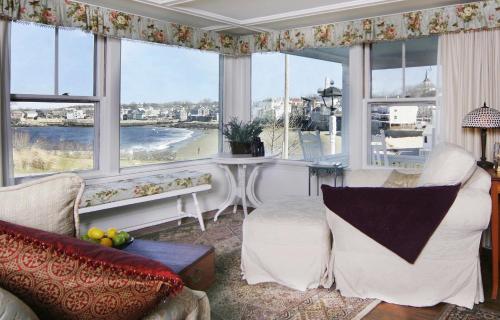 een woonkamer met ramen en uitzicht op de oceaan bij Beach & King Street Inn in Rockport