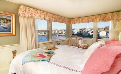 a bedroom with a white bed with a window at Beach & King Street Inn in Rockport