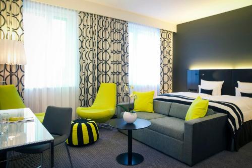 a hotel room with a bed and a couch at Vienna House by Wyndham Andel's Berlin in Berlin