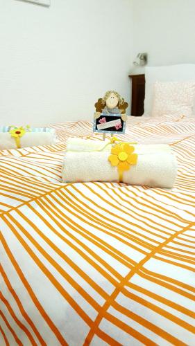 a bed with orange and white sheets and a stuffed animal on it at Studio Apartment Unity in Zagreb