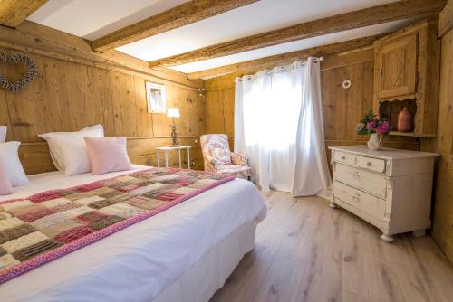 1 dormitorio con cama, ventana y vestidor en La Grange aux Coqs, en Ittenheim