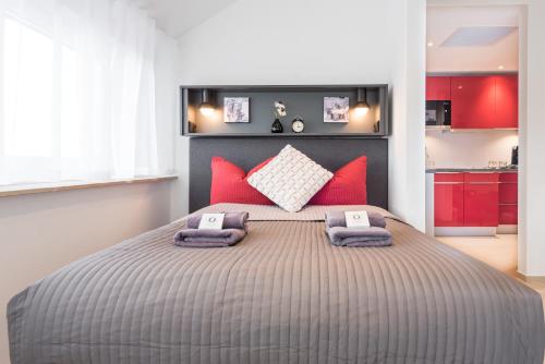 a bedroom with a large bed with red pillows at Friedrich Boutique-Apartments in Freiburg im Breisgau