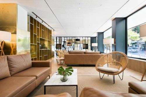 - un salon avec un canapé, des chaises et une table dans l'établissement Melia Madrid Serrano, à Madrid