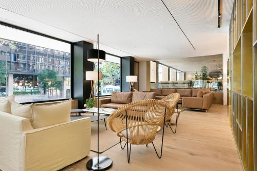 a living room with chairs and a table at Melia Madrid Serrano in Madrid