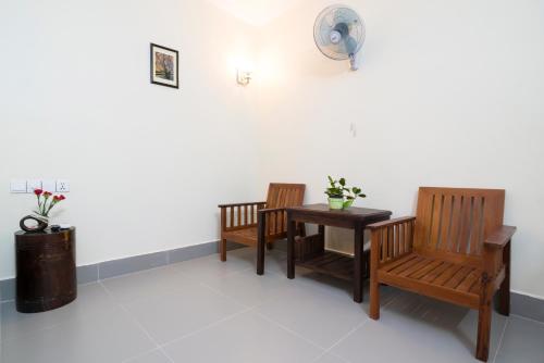 a room with two chairs and a table and a fan at Chamraoen’s Home in Siem Reap