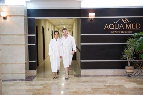 two men in white robes walking down a hallway at Lisova Pisnia Resort Hotel in Truskavets