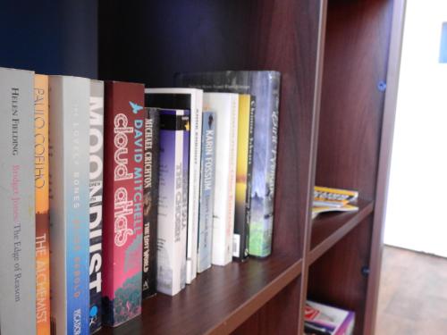 a row of books on a book shelf at Hull Trinity Backpackers in Hull