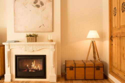 a living room with a fireplace and a lamp at Jardí de Ses Bruixes Boutique Hotel in Mahón