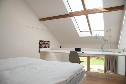 a bedroom with a bed and a desk and a window at Aiglberger Hofapartments in Steyr